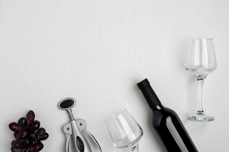 Red wine bottle, glasses and corkscrew over white background. Top view with copy spaceの写真素材