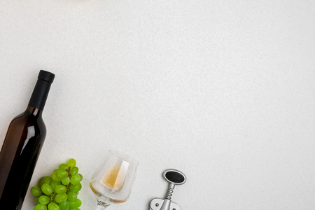 White wine bottle, glass and corkscrew over white background. Top view with copy spaceの写真素材
