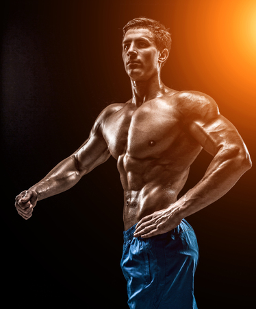 Muscular and fit young bodybuilder fitness male model posing oveの写真素材