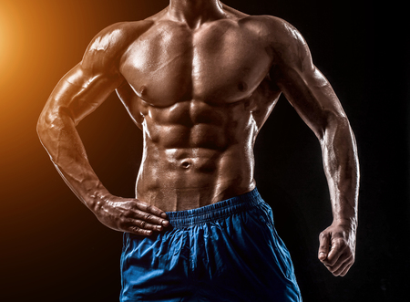 Muscular and fit young bodybuilder fitness male model posing oveの写真素材