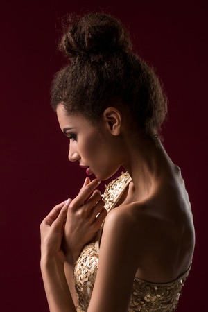 Fashion young African woman with make-up, in sexy gold dress.の写真素材