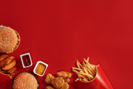 Burger and Chips. Hamburger and french fries in red paper box. Fast food on red background.の写真素材