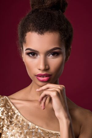Fashion young African woman with make-up, in sexy gold dress.の写真素材