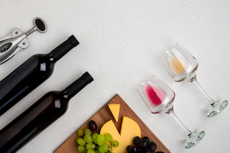 Two glasses of white and red wine, cheese and grapes. Top viewの写真素材