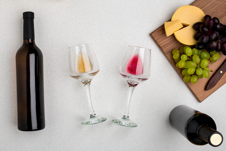 Two glasses of white and red wine, cheese and grapes. Top viewの写真素材