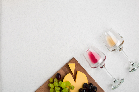 Two glasses of white and red wine, cheese and grapes. Top viewの写真素材