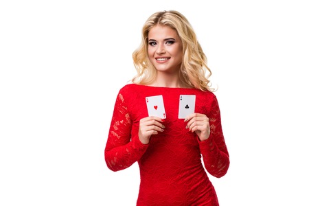 Caucasian young woman with long light blonde hair in evening outfit holding playing cards. Isolated. Pokerの写真素材