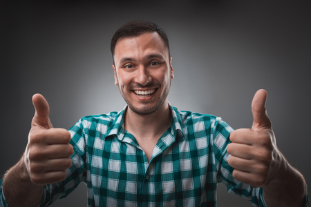 Portrait of excited happy man showing thumb up sign and smilingの写真素材