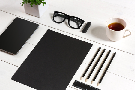 Modern workplace with digital tablet computer and mobile phone, cup of coffee, pen and empty sheet of paper.の写真素材