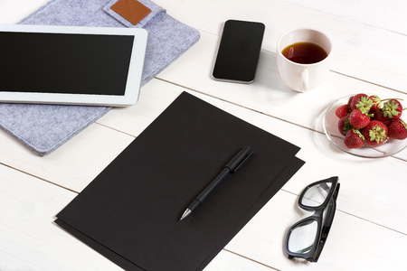 Modern workplace with digital tablet computer and mobile phone, cup of coffee, pen and empty sheet of paper.の写真素材