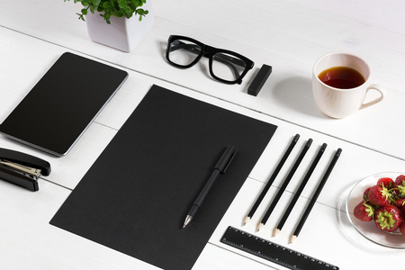 Modern workplace with digital tablet computer and mobile phone, cup of coffee, pen and empty sheet of paper.の写真素材