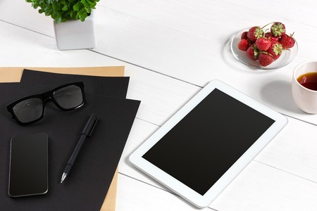 Modern workplace with digital tablet computer and mobile phone, cup of coffee, pen and empty sheet of paper. Top view and copy space for textの写真素材