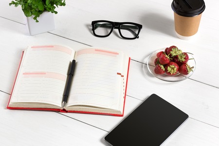 Stylish minimalistic workplace with tablet and notebook and glasses in flat lay style. White background.の写真素材