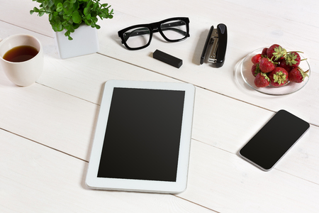 Flower pot, glasses, tablet, smart on white desktopの写真素材