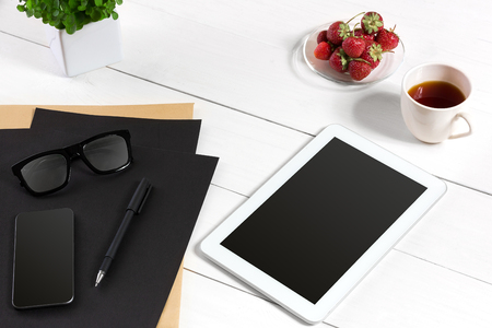 Tablet, blank sheet, glasses and coffee cup on office wooden tableの写真素材