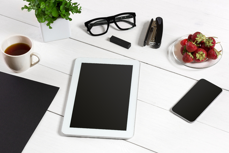 Tablet, blank sheet, glasses and coffee cup on office wooden tableの写真素材