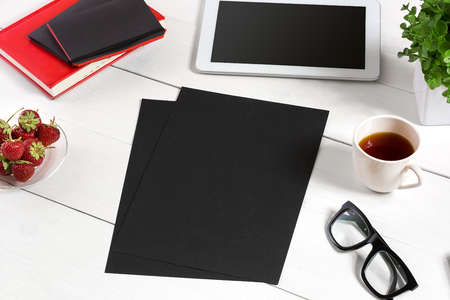 Stylish minimalistic workplace with tablet and notebook and glasses in flat lay style. White background.の写真素材
