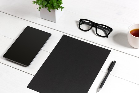 Tablet, blank sheet, glasses and coffee cup on office wooden tableの写真素材
