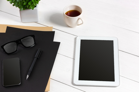 Tablet, blank sheet, glasses and coffee cup on office wooden tableの写真素材