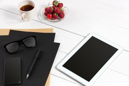 Tablet, blank sheet, glasses and coffee cup on office wooden tableの写真素材