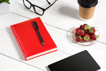 Stylish minimalistic workplace with tablet and notebook and glasses in flat lay style. White background.の写真素材