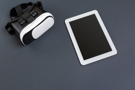 Virtual reality glasses and tablet on a gray background. Top viewの写真素材