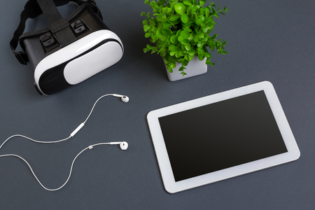 Virtual reality glasses and tablet with headphones on a gray background. Top viewの写真素材
