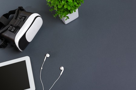 Virtual reality glasses and tablet with headphones on a gray background. Top viewの写真素材