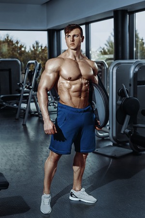 Sexy muscular man posing in gym, shaped abdominal. Strong male naked torso abs, working outの写真素材