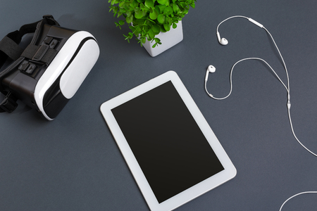 Virtual reality glasses and tablet with headphones on a gray background. Top viewの写真素材