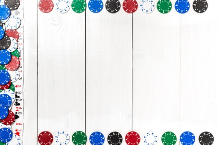 Playing cards and poker chips on white wooden background. Top view