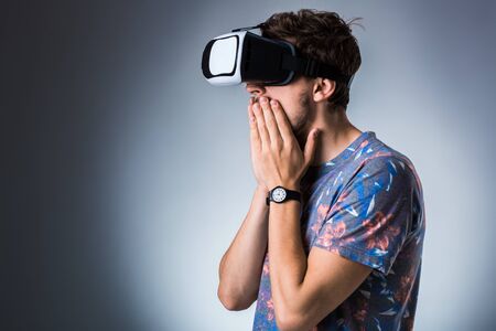 Side view of a young guy using a VR headset. Emotionsの写真素材