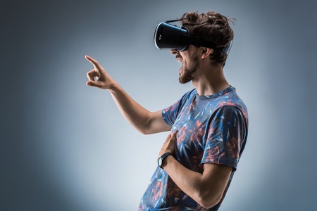 Side view of a young guy using a VR headset. Emotionsの写真素材
