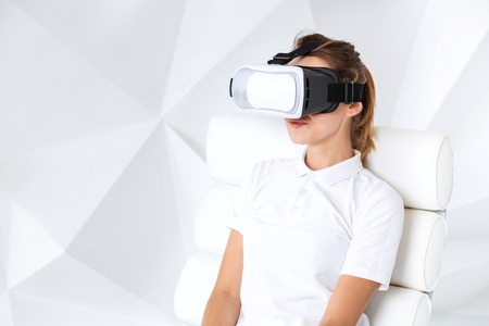 Happy woman getting experience using VR headset glasses of virtual reality at home much gesticulating hands.の写真素材