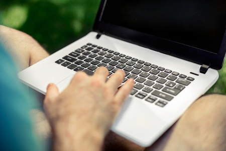 Top view male hands using notebook outdoors in urban setting while typing on keyboard, businessman freelancer working on computer while sitting on city park bench, tourist working on laptop, filterの写真素材