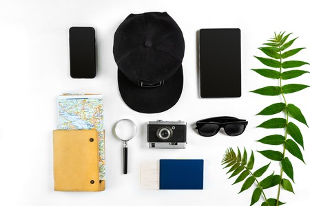 Travel accessories set on white background: smart, passport, cap, notepad, map, camera and sunglasses. Top view point. Flat lay. Still lifeの写真素材