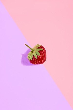 Fresh red strawberry isolated on pink-purple backgroundの写真素材