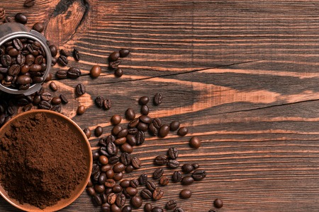 Coffee beans and ground coffee on rustic wooden table, view from above with space for text. Still life. Mock-up. Flat layの写真素材