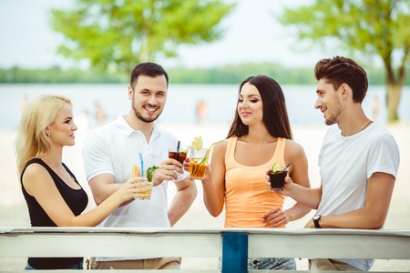 Friends having fun at the bar outdoors, drinking cocktails.の写真素材