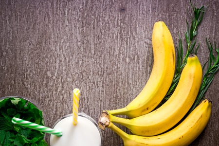Banana smoothie and fresh banana on wooden table. Top view. Copy space. Flat lay. Still lifeの写真素材