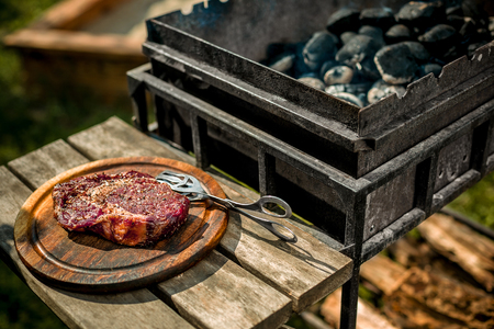 A thick strip steak being grilled outdoorsの写真素材