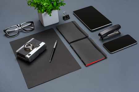 A set of black office accessories, glasses, old camera and tablet on gray backgroundの写真素材