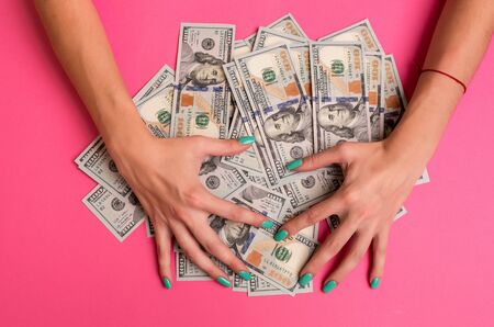 A woman is holding money in her hands. Pink background. Top view copy space.