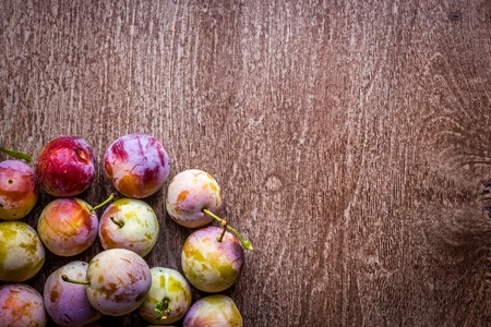 Fresh juicy plums on a wooden backgroundの写真素材