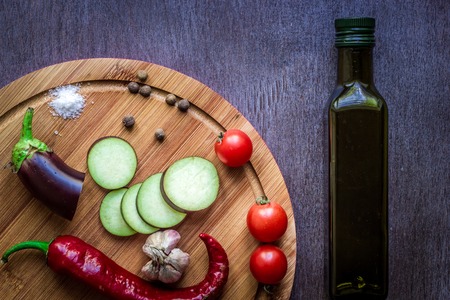 Healthy eating, vegetarian food. Raw eggplant prepared for frying in a frying pan with spices in olive oil. Top view. Wooden background. Copy space. Still life. Flat layの写真素材