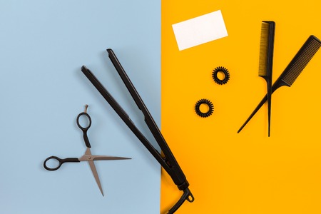 Various hair styling devices on the color blue, yellow paper background, top viewの写真素材
