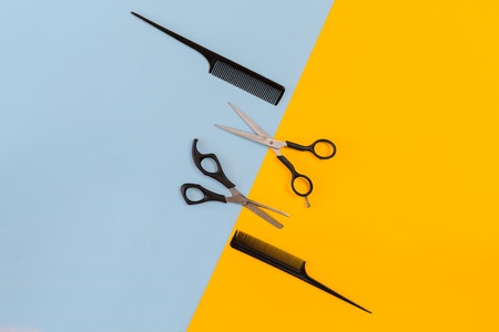 Hairdresser tools on blue and yellow background with copy space, top view, flat lay.の写真素材