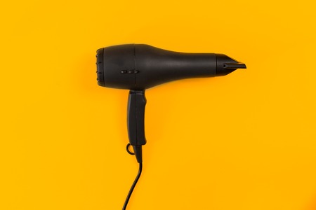 Black Hair dryer on orange backgroundの写真素材