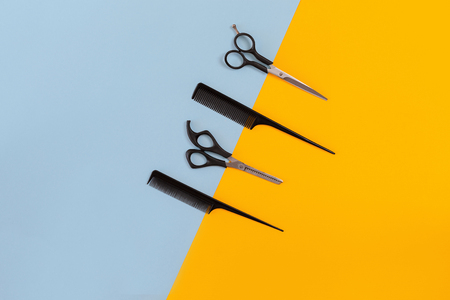 Hairdresser set with various accessories on orange and blue backgroundの写真素材