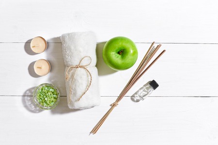 Spa products. Bath salts, soap, candles and towel. Flat lay on white wooden background, top view.の写真素材